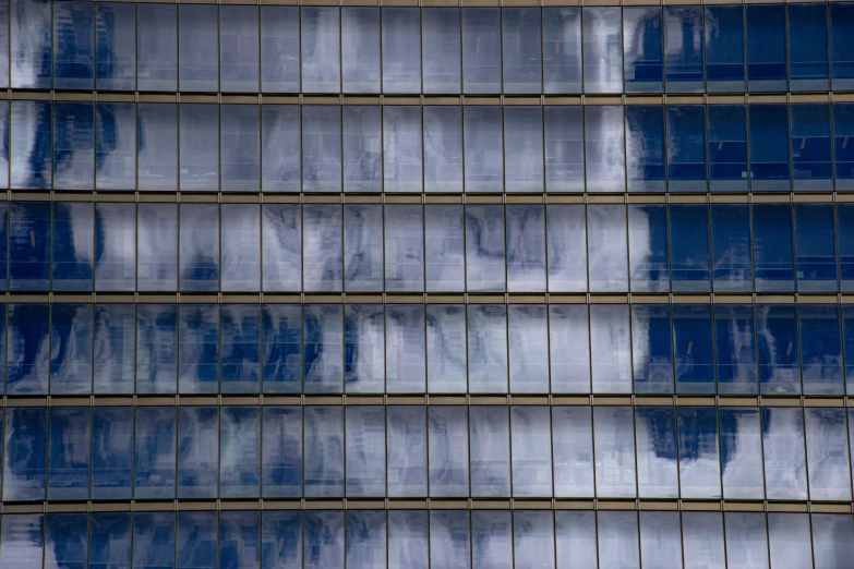 a skyscr in new york city with several windows reflecting the sky