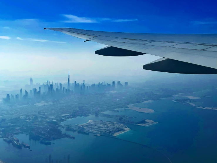 a view out an airplane window with the city in the distance