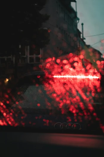 a view of a stop sign with rain and red street lights