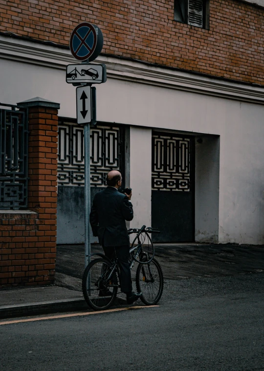 a person standing at a street corner next to a clock