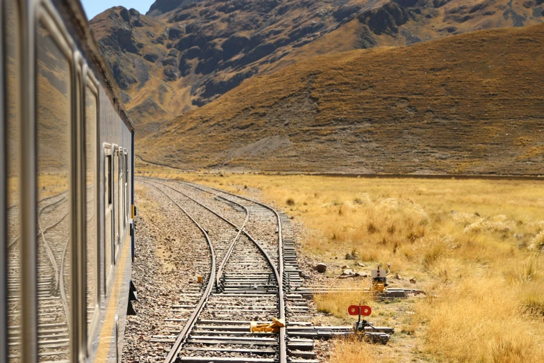 there is a train going down the tracks near mountains