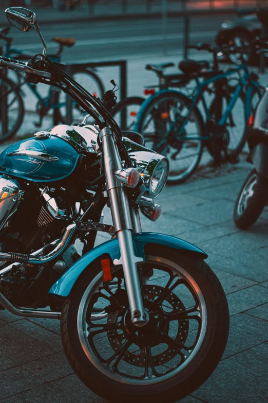 motorcycle parked in front of many bikes in a bike rack