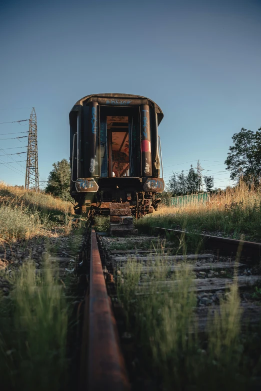 a train on train tracks in grassy area next to power lines