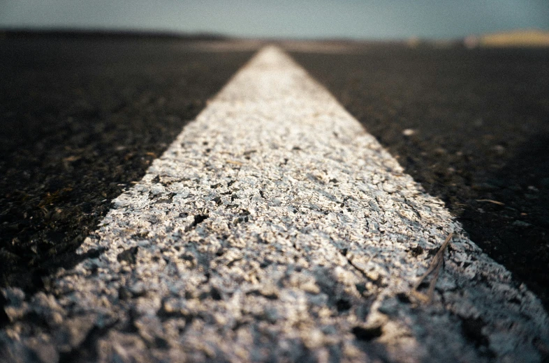 an empty straight road with no markings