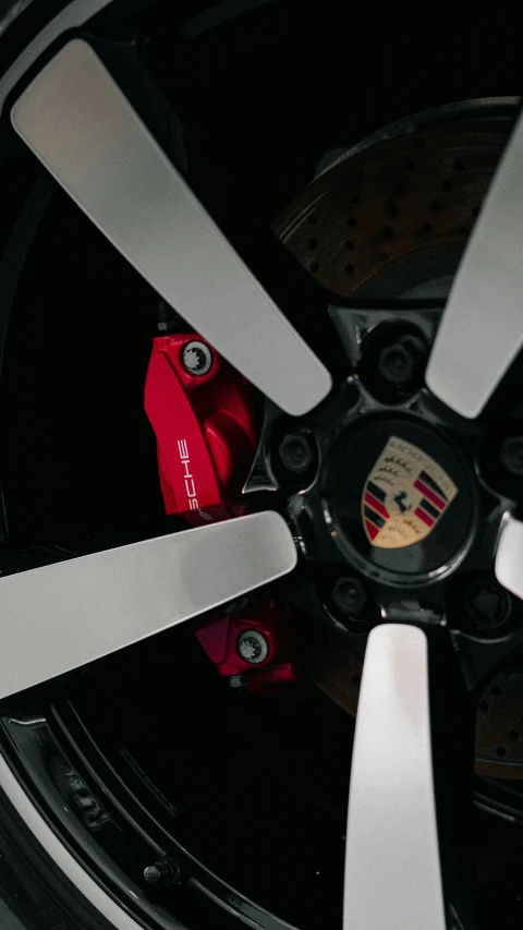 a wheel with white trim and red caliper sitting on the side