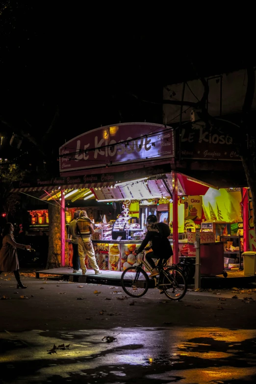 an image of people riding bicycles around at night