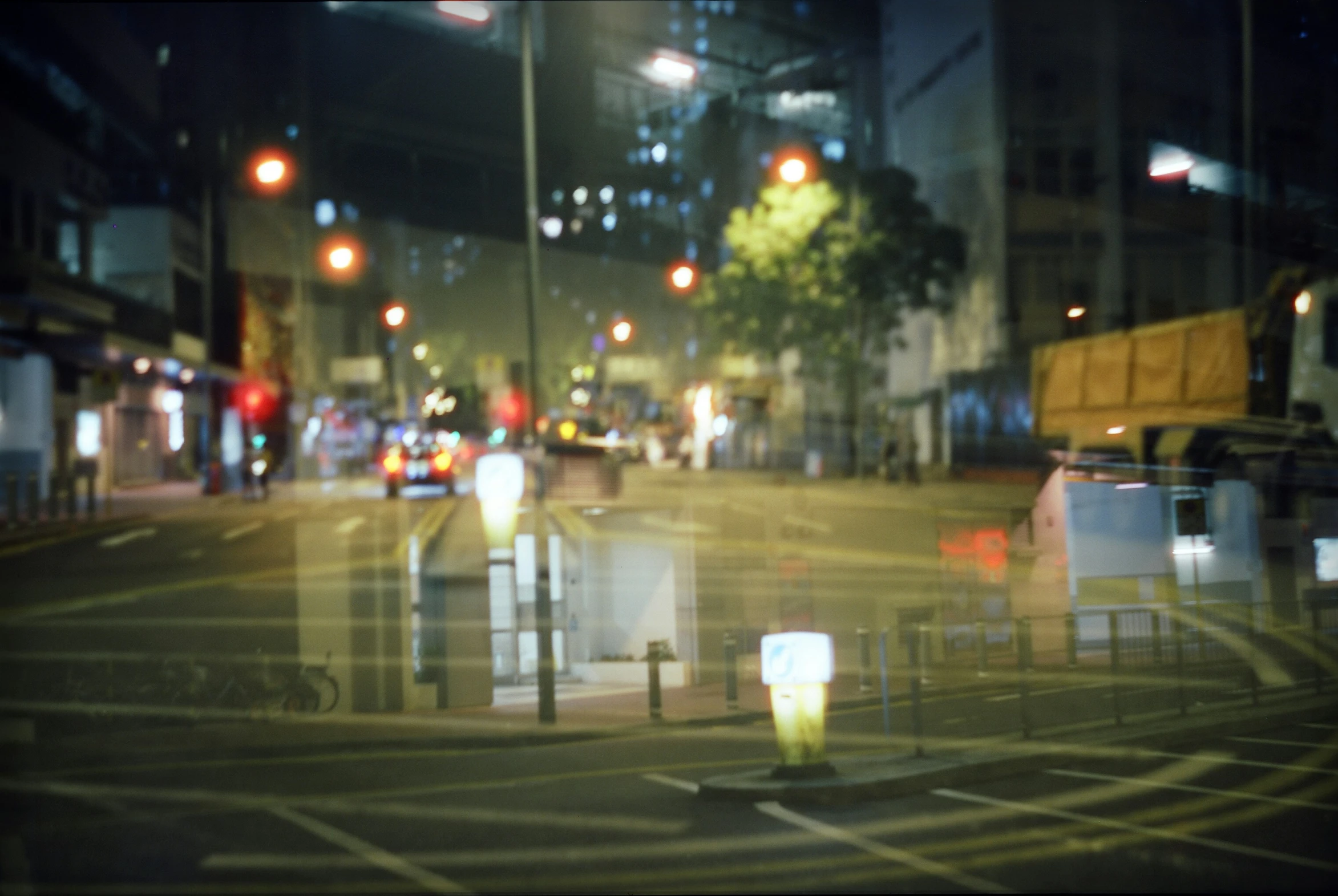 some people standing on a street with cars and trees