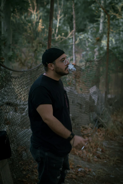 a man standing outside drinking from a water bottle