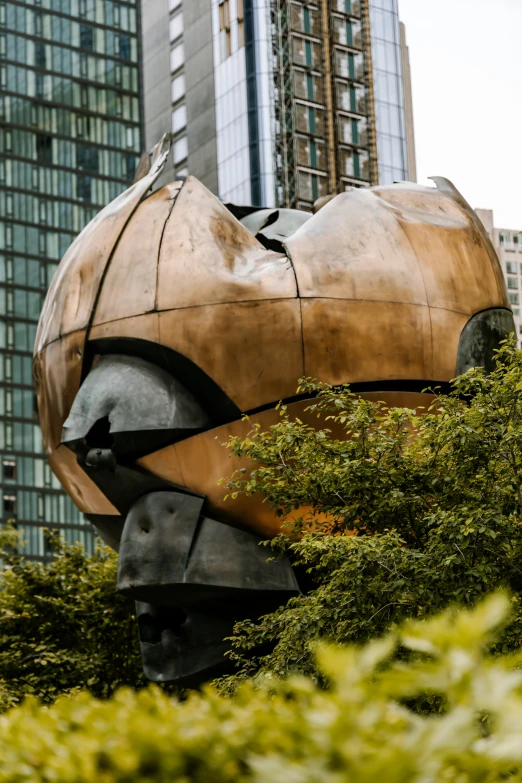 an artistic sculpture sits outside near tall buildings