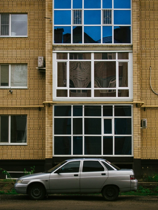 a grey car is parked outside a building