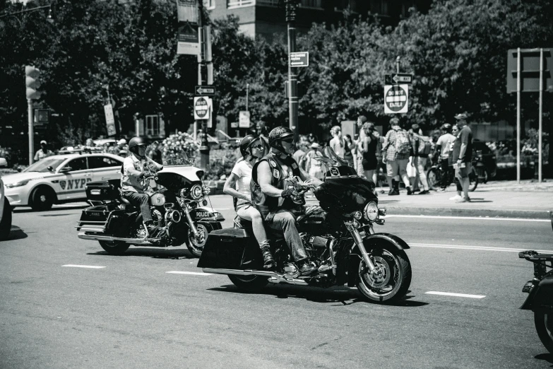 several people riding motorcycles through the city