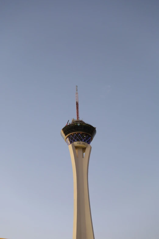 an airplane flying by the tower and clear sky