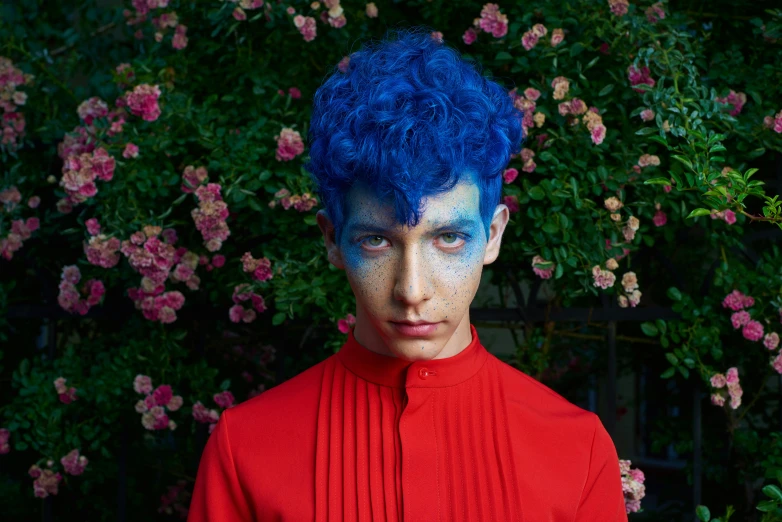 a man with blue hair and blue makeup wearing red