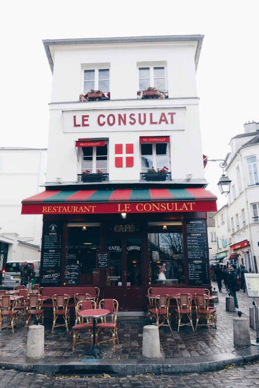 a red and white restaurant on a cobblestone street in paris