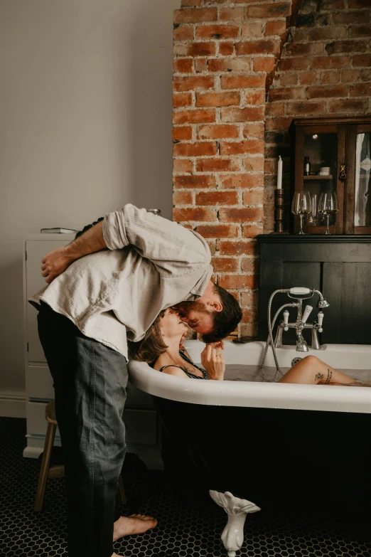 a man standing over a woman in a bathtub