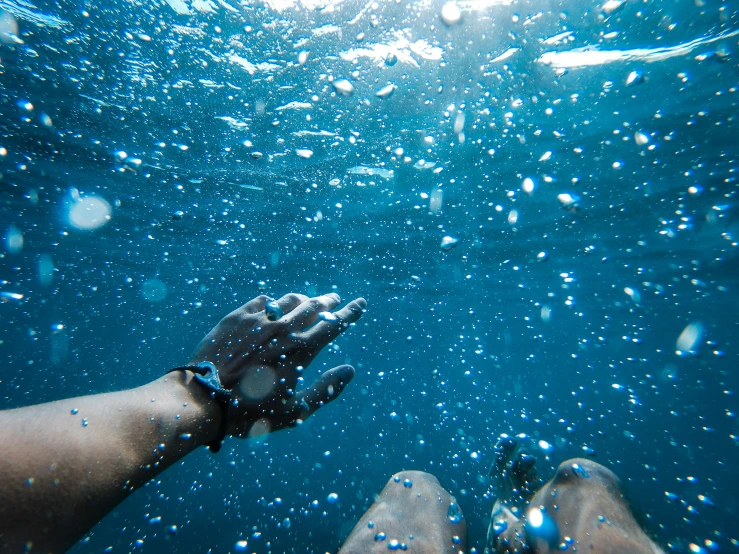 the hand of someone beneath water near a person