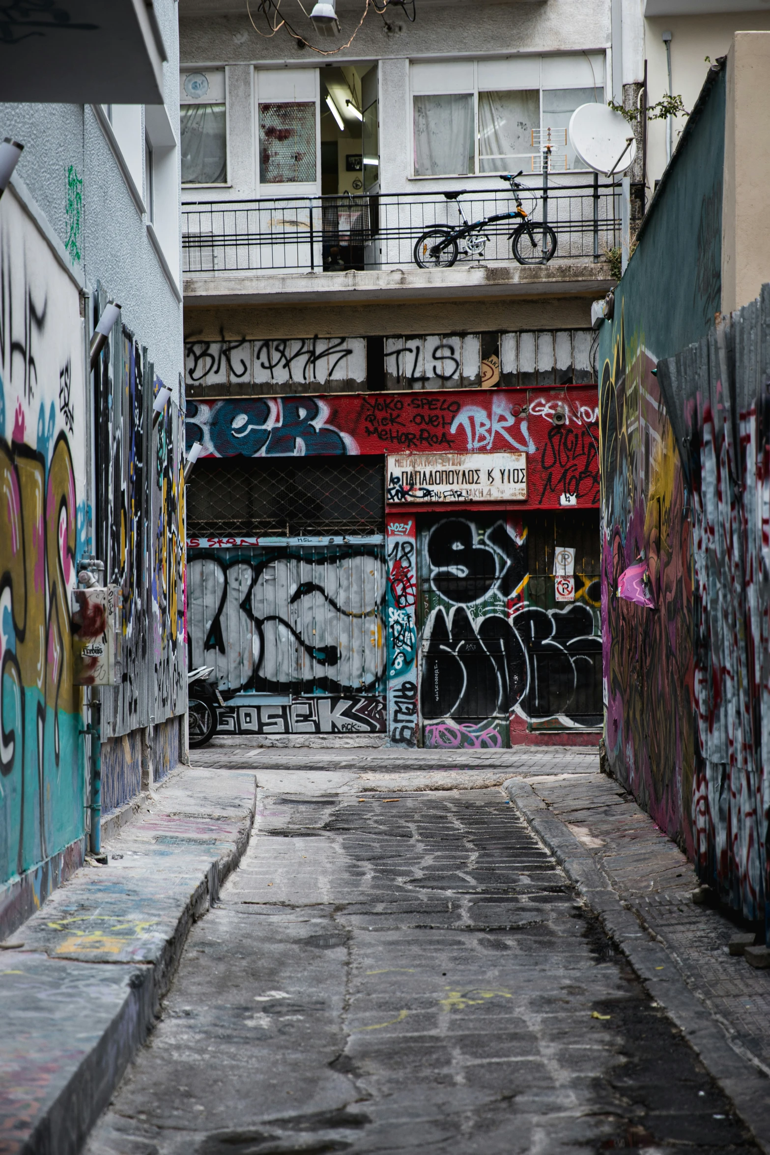 some graffiti in an alley under an apartment