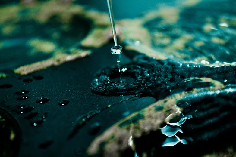 water dripping from a faucet in a pool of water