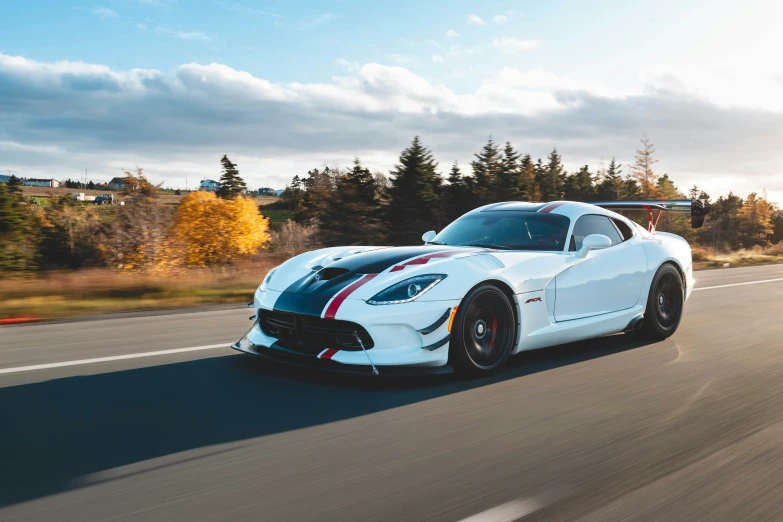 a white sports car driving down the street