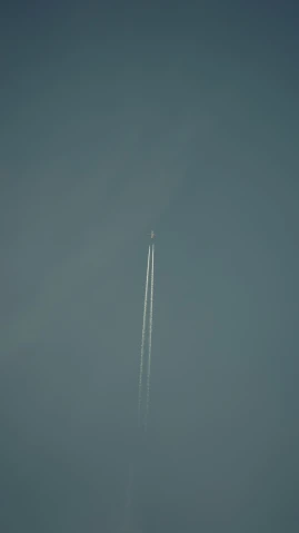 a plane flies through the air while trailing smoke