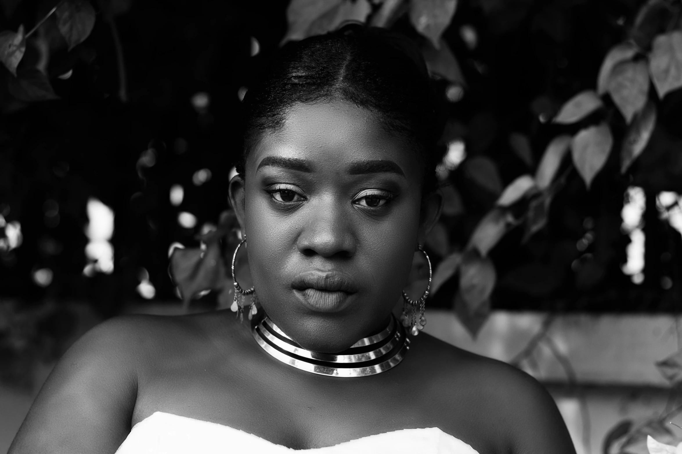 a black woman in a strapless dress and hoop earrings