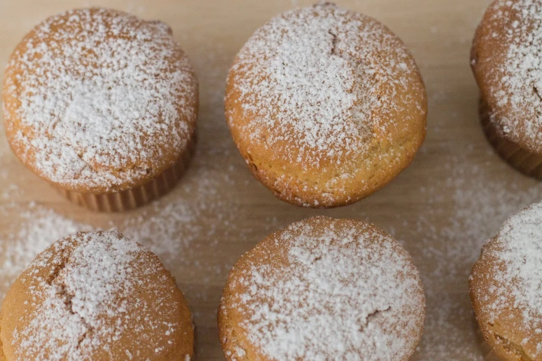 eight delicious baked treats with powdered sugar in the middle