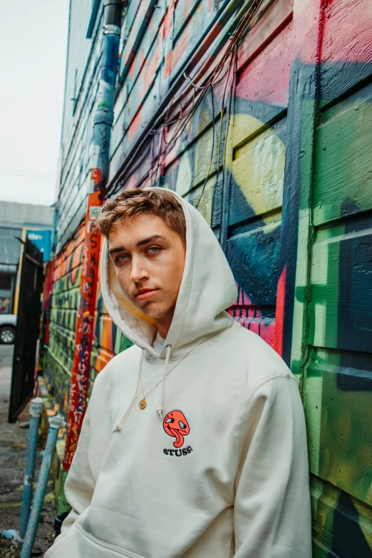 a person leaning against a wall on a street