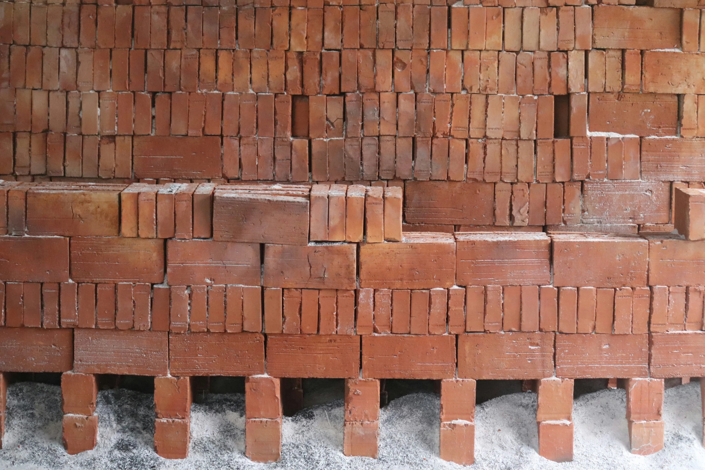 a wall made out of many bricks is covered by snow