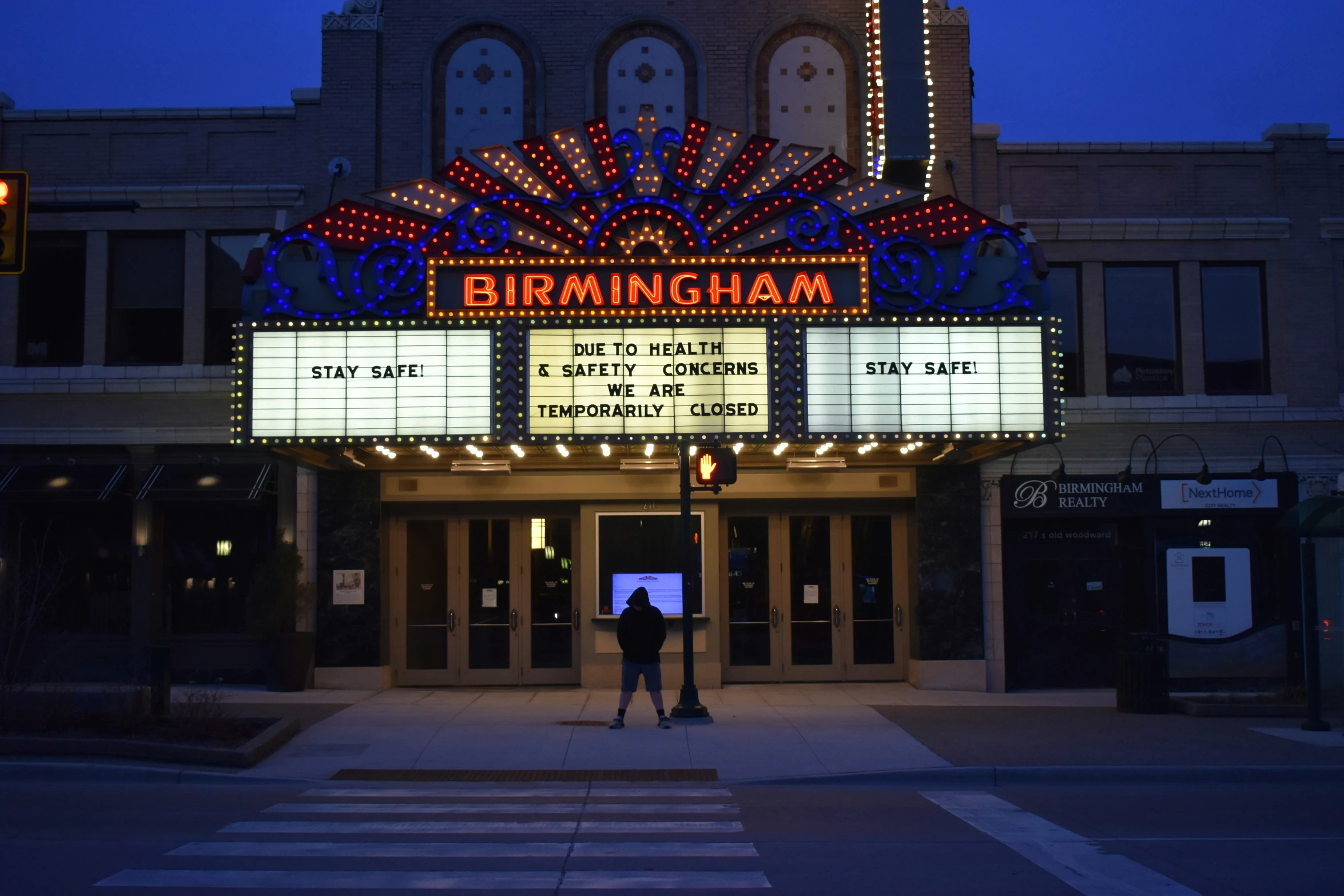 a movie theater with a bright sign lit up at night