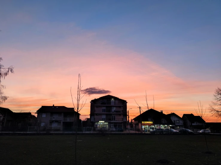 a pink and blue sky behind the buildings