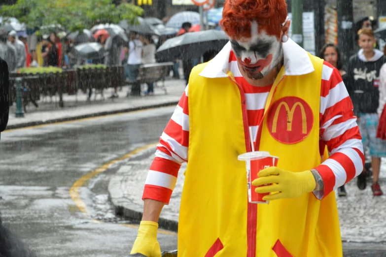 man in orange and white costume holding an iced drink