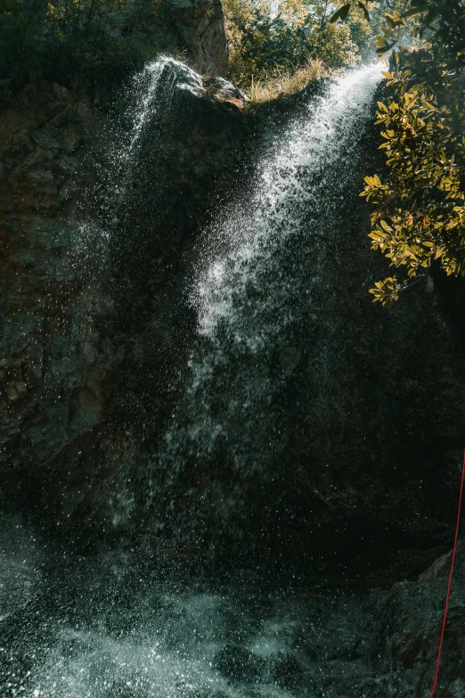 a man on a water ski next to a large waterfall