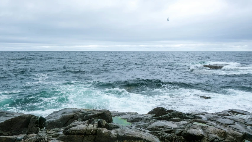 the ocean and rocks are full of white foamy water