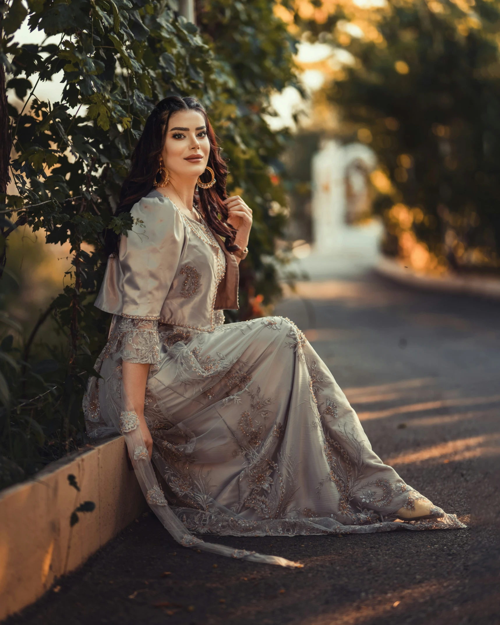 a woman with long hair posing against a tree