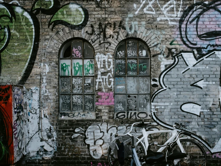 a motorcycle parked against a brick wall with graffiti