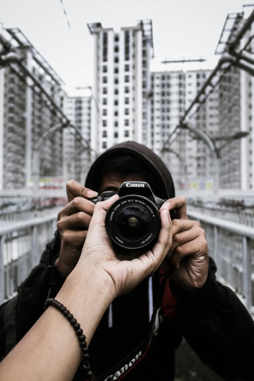 someone holding a camera in front of a building