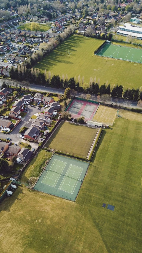 an aerial s of a tennis court with lots of green grass