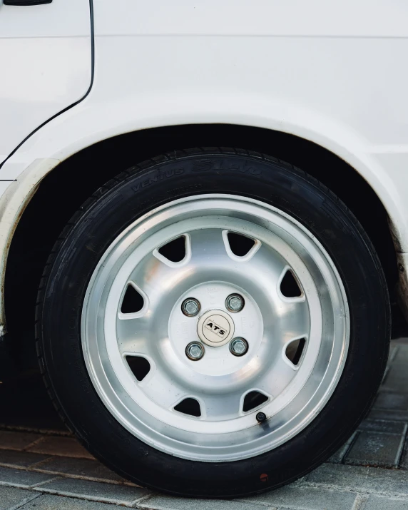 a white car with a big wheel on it's front tire