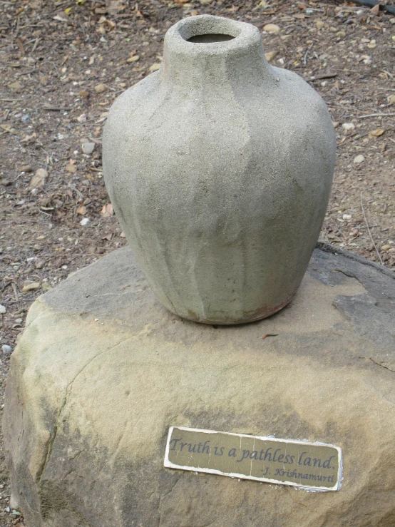 a clay jar is sitting on a rock