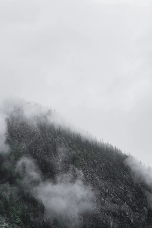 a hill is covered in fog during the daytime