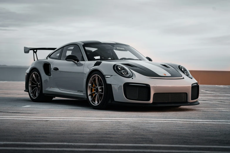 a white porsche sports car sits on the pavement