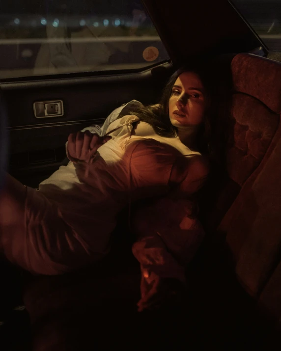 a woman laying down in a car seat