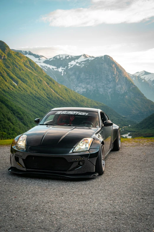 a black car parked on the side of a mountain road