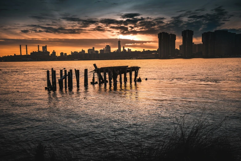 the sun rising behind a city skyline and water