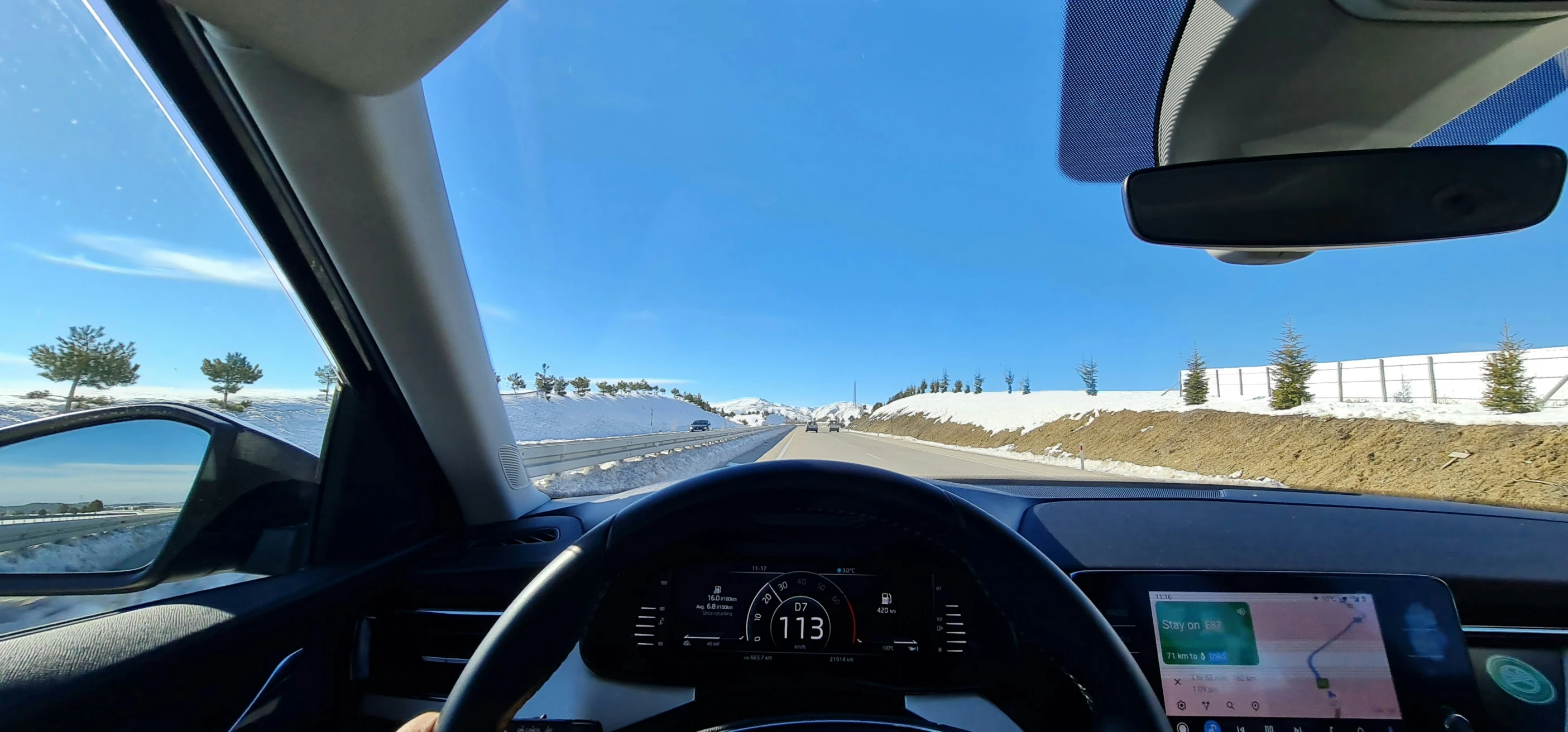 the dashboard of a car going down a snowy highway