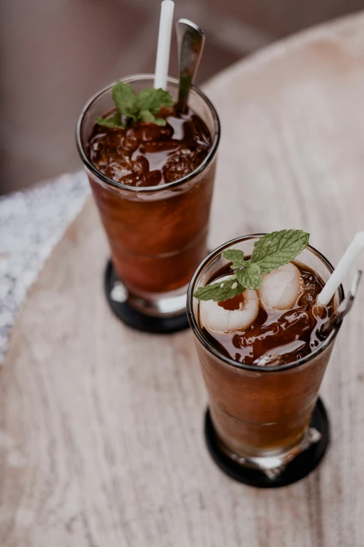 two glasses of drinks on a wooden table