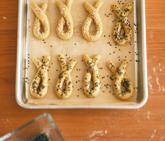 pretzels with seasoning sit on top of a baking tray