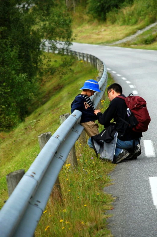 two men standing on a bridge with backpacks