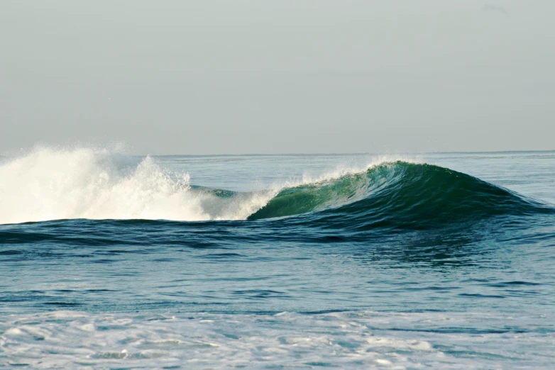 an ocean wave with the sky above it