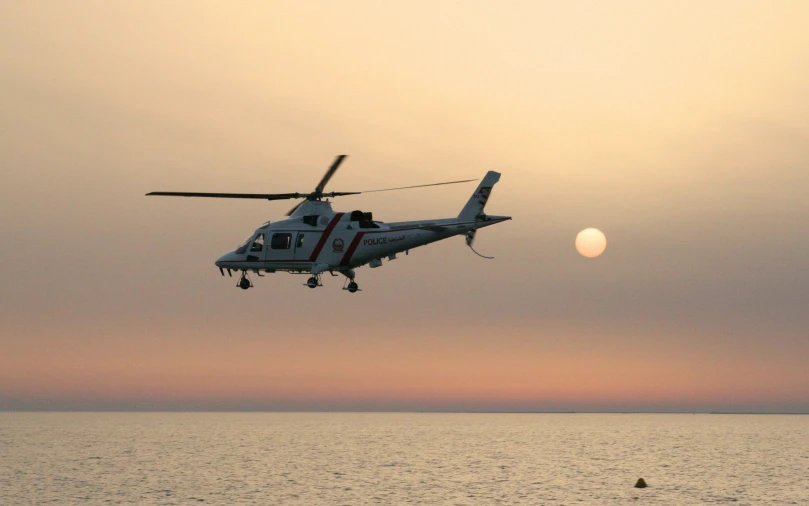 a helicopter is flying in the sky over the water